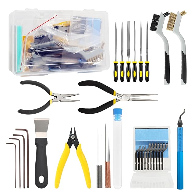Ausgelegtes Set: transparente Box, sechs Feilen, zwei Bürsten, zwei Spitzzangen, Seitenschneider, Schaber, vier Innensechskantschlüssel, Nadeln in einem Röhrchen, zehn Klingen und ein blauer Entgrater